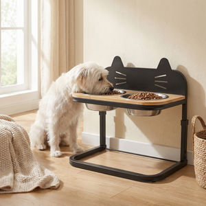 White dog eating from elevated cat-shaped pet feeder with two stainless steel bowls near sunny window