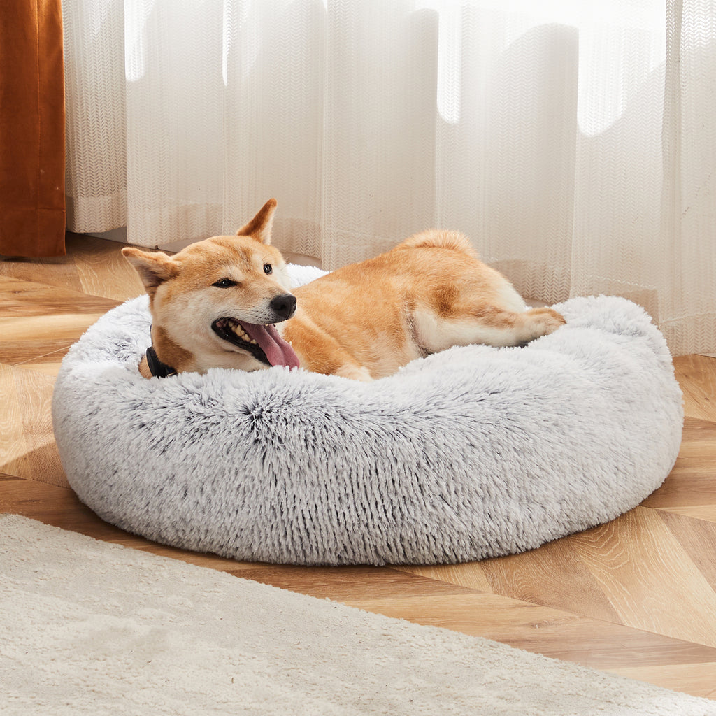 Cat curled up in plush faux fur round pet bed