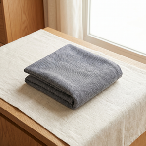 Folded gray pet cooling mat on wooden surface, ideal for cats and dogs comfort