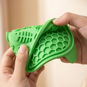 Green fish-shaped silicone pet slow feeder with honeycomb texture for cats and dogs